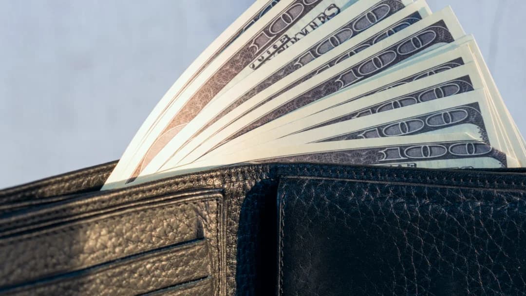 A wallet filled with cash, symbolizing the accessibility of instant microloans for financial empowerment.