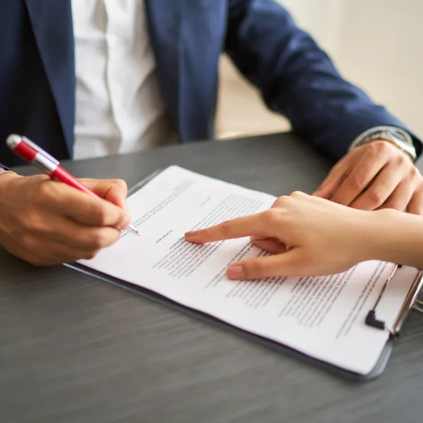 A man and woman signing a contract on a desk for a fast loan.