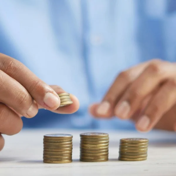 A person counts coins on a table, symbolizing the financial empowerment of instant microloans.