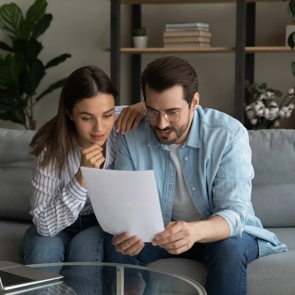 Couple reviewing loan paperwork on a couch, discussing options for no credit check loans.