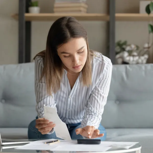 Woman looking at her bills on the table.